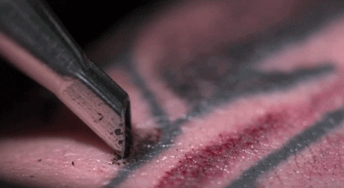 Agulha de tatuagem oscilando em alta velocidade e perfurando a pele