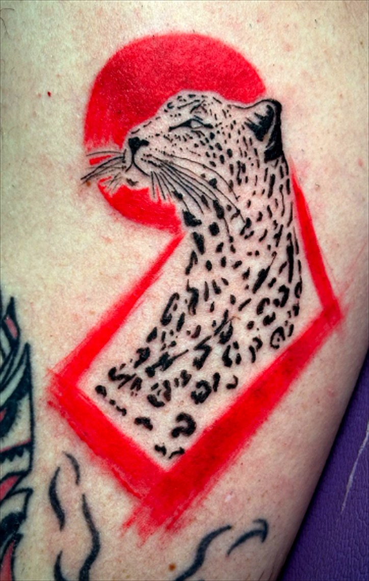 Tatuagem de leopardo em preto com sol e moldura vermelhos