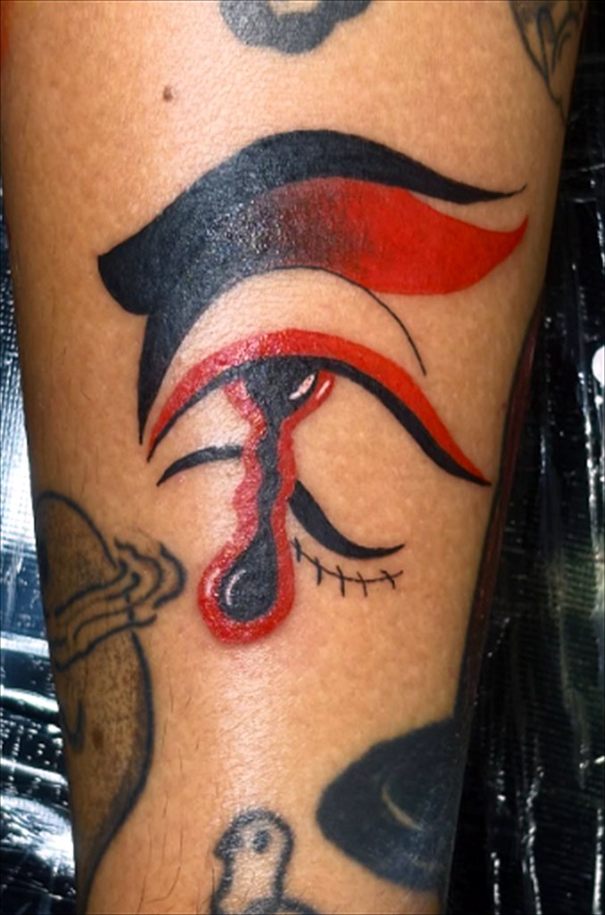 Tatuagem de olho com lágrima em preto e vermelho