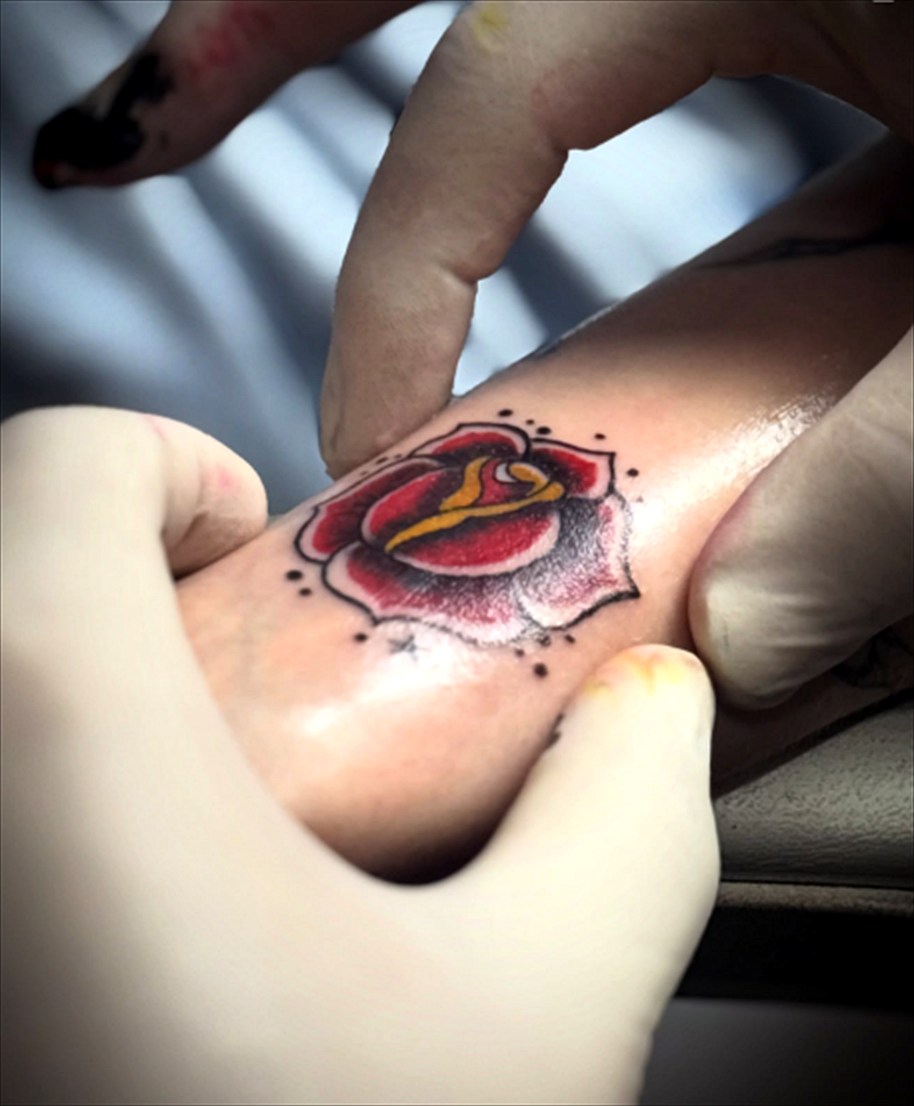 Tatuagem tradicional de rosa em vermelho e amarelo