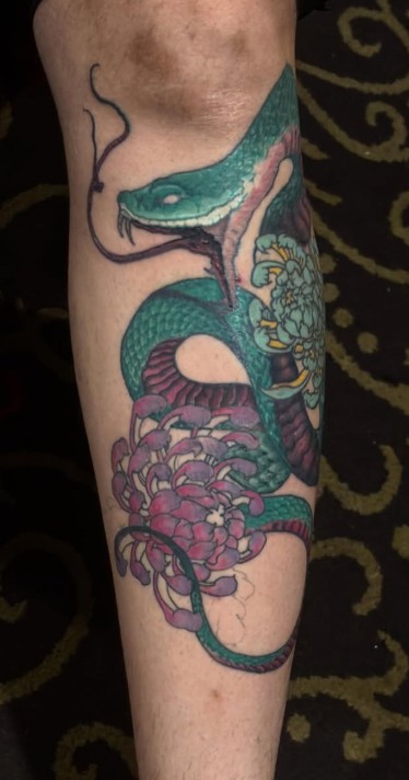 Tatuagem oriental de serpente e crisântemos em bold lines e cores